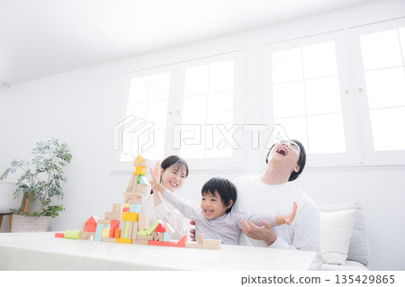 父母在客廳和孩子玩耍，其樂融。假期育兒真不容易。 135429865