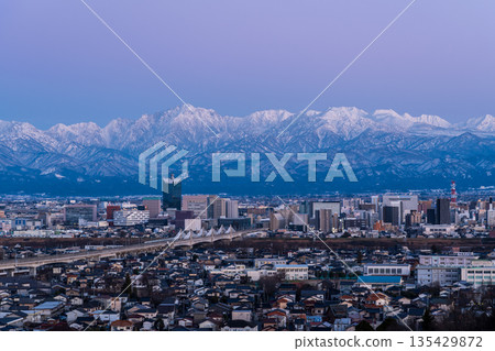 View of the Toyama cityscape and the Tateyama mountain range Abenrot from the observation deck at Kurehayama Park in Toyama City in the evening View of the Toyama cityscape and the Tateyama mountain range Abenrot from the observation deck at Kurehayama Park in Toyama City in the evening 135429872
