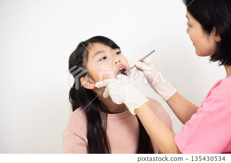 Elementary school girl receiving a medical examination at a dental clinic 135430534