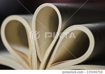 Extreme close up of book pages forming a rhythmic curved pattern 135430758