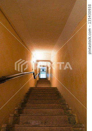 The narrow, dimly lit staircase 135430938