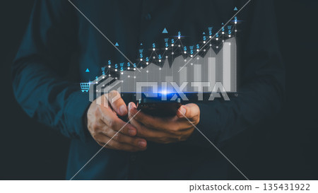 Businessman analyzing e-commerce growth graph on smartphone, showing rising sales performance, digital marketing success, and online business strategy with data analytics concept for financial growth. Businessman analyzing e-commerce growth graph on smartphone, showing rising sales performance, digital marketing success, and online business strategy with data analytics concept for financial growth. 135431922
