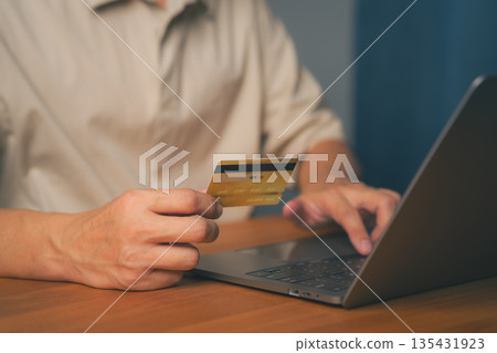 Online payment and e-commerce concept showing adult man using a credit card with a laptop computer, representing digital banking, financial transactions, and secure internet shopping technology. Online payment and e-commerce concept showing adult man using a credit card with a laptop computer, representing digital banking, financial transactions, and secure internet shopping technology. 135431923