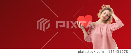 Valentines Day scene shows woman smiling and holding heart Valentines Day scene shows woman smiling and holding heart 135431978