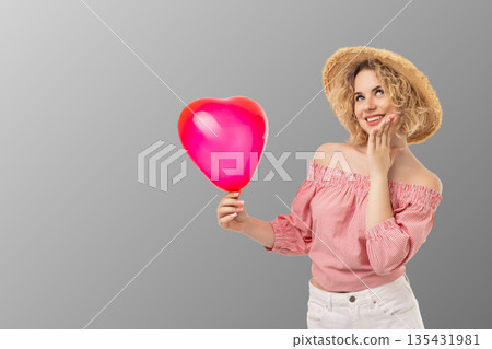 Girl with pink heart balloon smiles for Valentine's Day 135431981