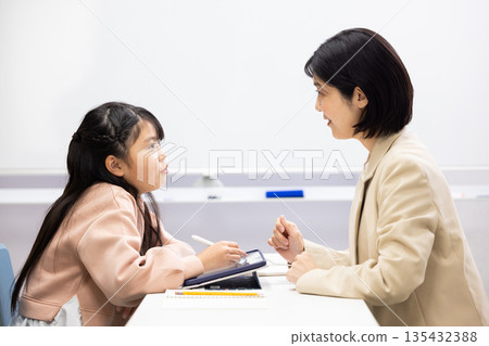 An elementary school girl being taught by a cram school teacher 135432388