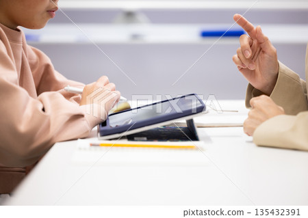 補習班老師和一位小學生進行一對一輔導的特寫鏡頭 135432391