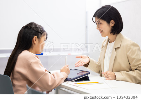 一位女補習班老師正在教小學生。 135432394