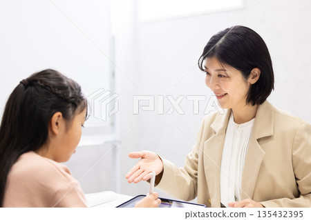 一位女補習班老師正在教小學生。 135432395