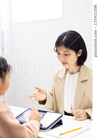 一位女補習班老師正在教小學生。 135432396