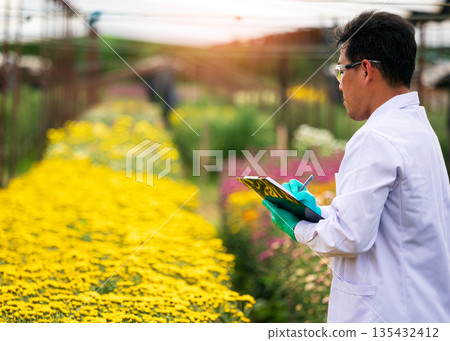 Agricultural scientist in white lab coat and gloves observing and taking notes in a vibrant flower field, symbolizing floriculture research, crop monitoring, smart farming, and environmental science Agricultural scientist in white lab coat and gloves observing and taking notes in a vibrant flower field, symbolizing floriculture research, crop monitoring, smart farming, and environmental science 135432412