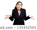 Asian businesswoman in black suit shrugging with confused expression on white background, representing uncertainty, doubt, lack of decision, business confusion, or unclear communication in workplace 135432503