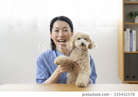 A woman in her 50s and her pet dog talking to the camera A woman in her 50s and her pet dog talking to the camera 135432570