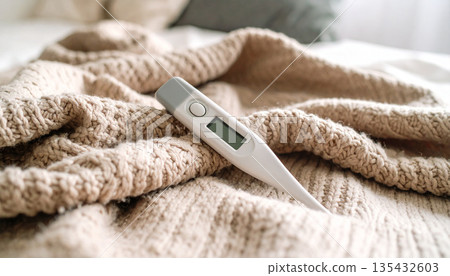 體溫計放在毯子上。一幅寧靜祥和的健康管理畫面。 135432603