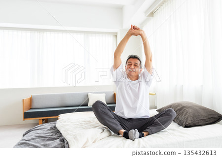 Middle-aged man stretching in bed 135432613