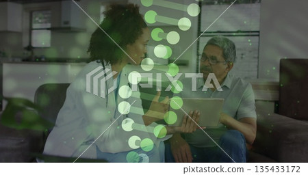 Pointing stethoscope doctor guiding senior patient with tablet on home sofa, with DNA helix overlay 135433172