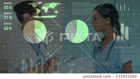 Standing two nurses discussing data in hospital hall with stethoscopes, ID badge, digital overlays 135433260