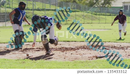 Bending catcher wearing gear picking up loose softball on dirt infield, with catcher's mitt Bending catcher wearing gear picking up loose softball on dirt infield, with catcher's mitt 135433312