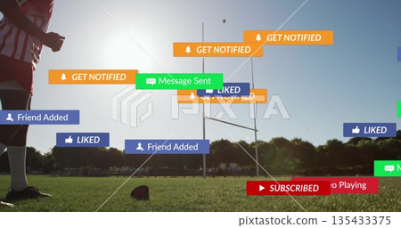 Standing teen athlete wearing red jersey on field with rugby ball and notifications, copy space 135433375