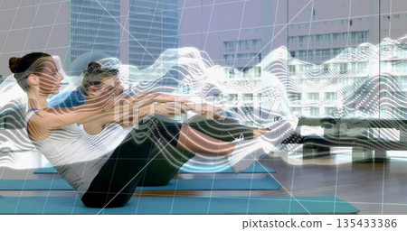 Balancing on blue mats three adults in athletic shoes lifting legs at gym, motion tracking overlays Balancing on blue mats three adults in athletic shoes lifting legs at gym, motion tracking overlays 135433386