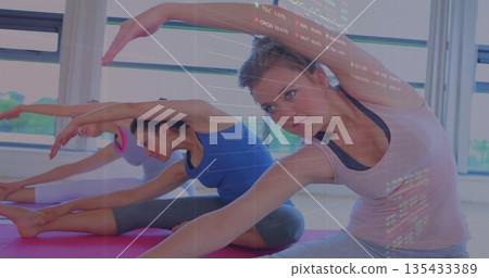 Stretching woman in sportswear reaching toward leg on yoga mat in yoga studio, copy space 135433389
