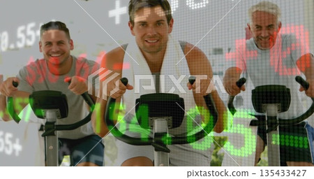 Pedaling three men on exercise bikes in fitness studio, with white towel and red-green data overlay 135433427