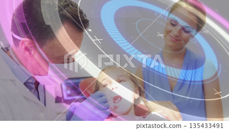 Examining dentist wearing mask and gloves inspecting girl wearing bib in dental chair, with mirror 135433491