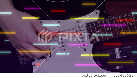 Strumming musician's right hand playing white electric guitar in music studio, with colored bars Strumming musician's right hand playing white electric guitar in music studio, with colored bars 135433525