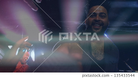 Smiling performer reaching toward camera at club stage, with mic stand, copy space 135433544