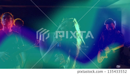 Gripping microphone stand female vocalist singing on hazy stage with electric guitars and cables Gripping microphone stand female vocalist singing on hazy stage with electric guitars and cables 135433552