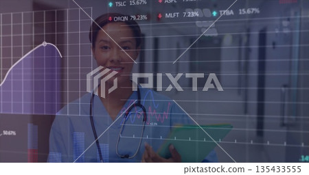 Standing nurse in scrubs and stethoscope holding green folder in hospital hall with digital charts 135433555