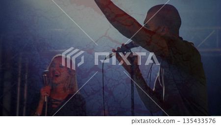 Performing male singer with headphones raising hand with microphone on stage with truss, copy space Performing male singer with headphones raising hand with microphone on stage with truss, copy space 135433576