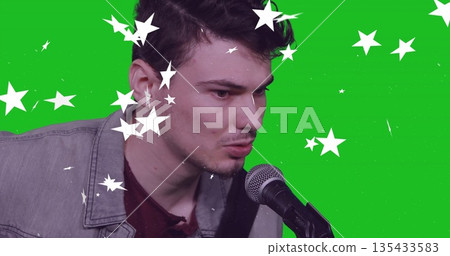 Singing into microphone singer wearing denim jacket in recording studio, with green screen stars Singing into microphone singer wearing denim jacket in recording studio, with green screen stars 135433583