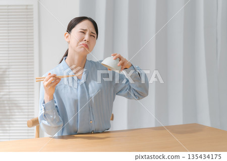 Woman turning a rice bowl upside down 135434175
