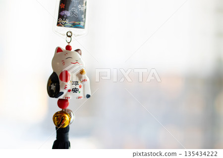 Hanging ceramic lucky cat with tassels and coin induces calmness in intimate tea shop environment Hanging ceramic lucky cat with tassels and coin induces calmness in intimate tea shop environment 135434222