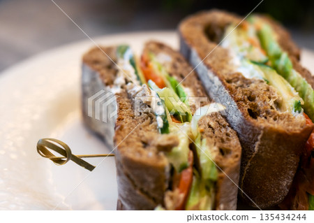 Beautiful photo showcasing nutritious multilayered bread creation in warm ambiance 135434244