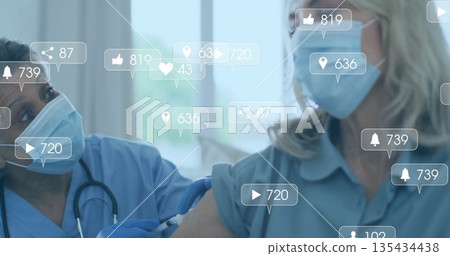 Clinic nurse injecting vaccine into patient arm with scrubs, mask, syringe and social media icons Clinic nurse injecting vaccine into patient arm with scrubs, mask, syringe and social media icons 135434438