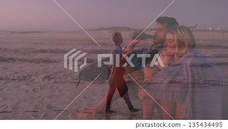 Hugging couple sipping dark bottle at shoreline at dusk, with fringed blanket and pastel sky Hugging couple sipping dark bottle at shoreline at dusk, with fringed blanket and pastel sky 135434495