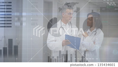 Two doctors conversing in hospital hallway, stethoscopes and blue clipboard, data overlays Two doctors conversing in hospital hallway, stethoscopes and blue clipboard, data overlays 135434601