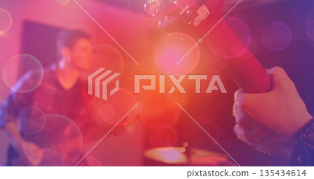 Gripping musician hand fretting electric guitar under colored stage lights bokeh flares, copy space Gripping musician hand fretting electric guitar under colored stage lights bokeh flares, copy space 135434614