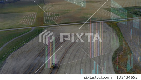 Plowing yellow tractor navigating furrows and dirt road over farm field with digital data overlays 135434652