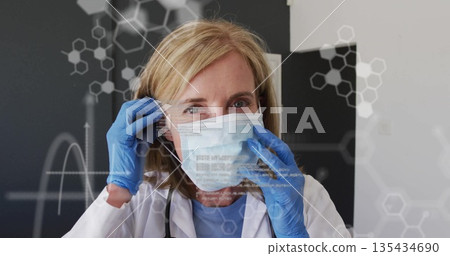 Doctor in lab coat, blue gloves adjusting surgical mask in clinic, stethoscope molecular graphics Doctor in lab coat, blue gloves adjusting surgical mask in clinic, stethoscope molecular graphics 135434690