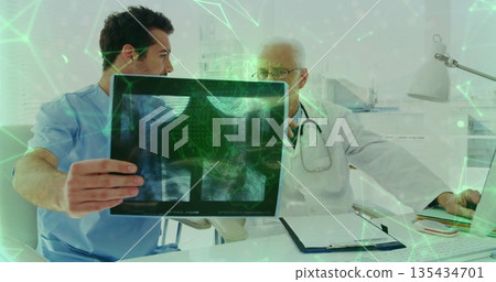 Holding chest X-ray film, doctor in scrubs examining scan in clinic with digital overlay 135434701