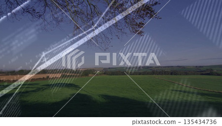 Lush pasture casting tree shadows through glass pane view with plowed fields and code reflections 135434736
