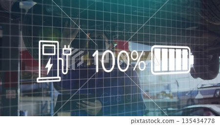 Inspecting technician in navy coveralls examining electric vehicle in garage with overlay icons 135434778
