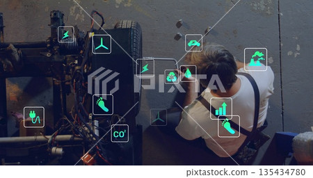 Kneeling mechanic tightening fasteners on wheel axle at workshop, with wrench, bolts, copy space Kneeling mechanic tightening fasteners on wheel axle at workshop, with wrench, bolts, copy space 135434780