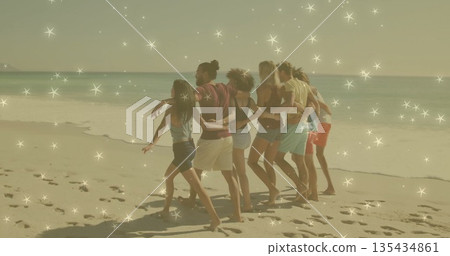 Walking seven friends in beachwear linking arms on sandy beach, showing footprints and ocean water Walking seven friends in beachwear linking arms on sandy beach, showing footprints and ocean water 135434861