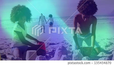 Kids in trunks kneeling and building sandcastles at beach, buckets footprints and parents walking Kids in trunks kneeling and building sandcastles at beach, buckets footprints and parents walking 135434870