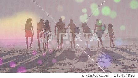 Walking eight adults carrying surfboards wearing board shorts along shoreline at sunset, pastel sky 135434886