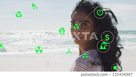 Standing woman wearing striped top glancing back on beach, floating environmental icons, copy space Standing woman wearing striped top glancing back on beach, floating environmental icons, copy space 135434907